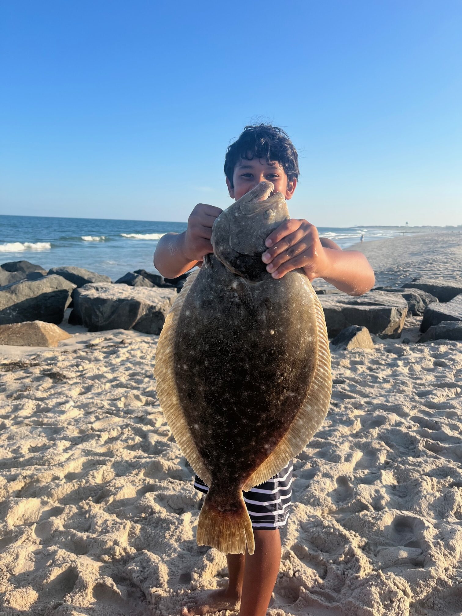 Kellen (kids clinic graduate) caught this 24.5″ fluke off the beach